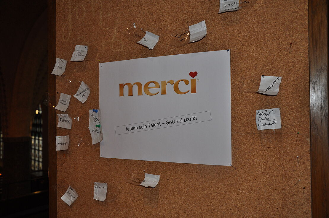Ein Blatt Papier mit Merci an einem Pinboard angesteckt.