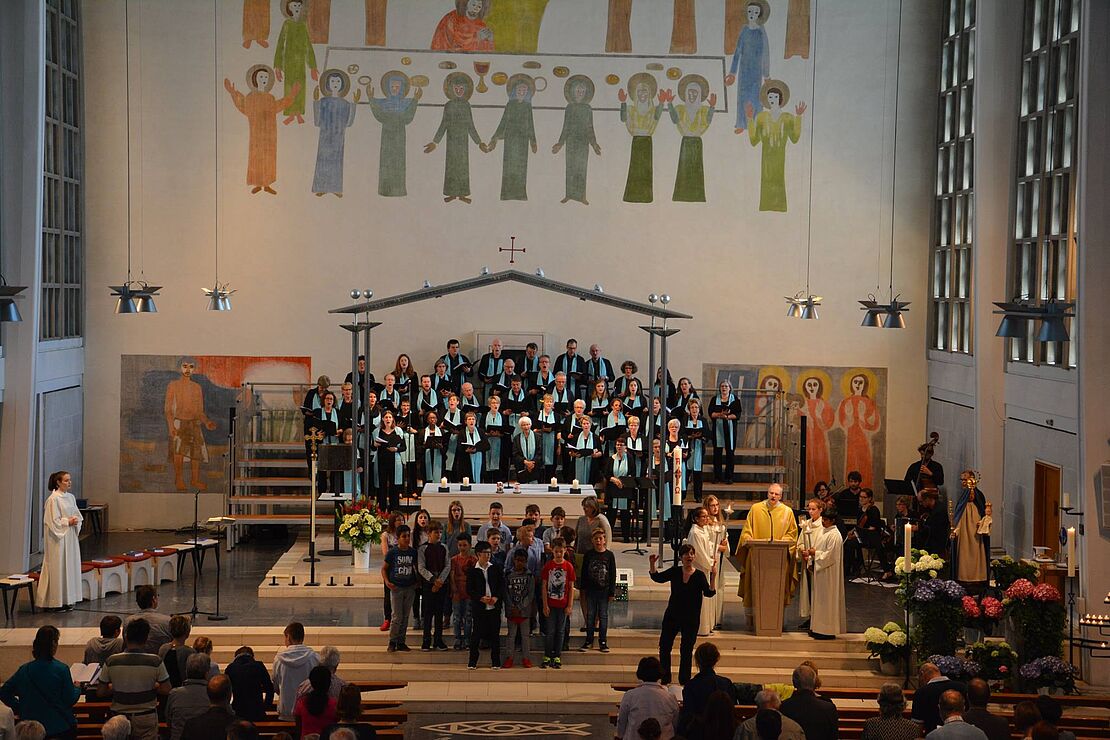 Ein Kirchenchor singend auf der Bühne.