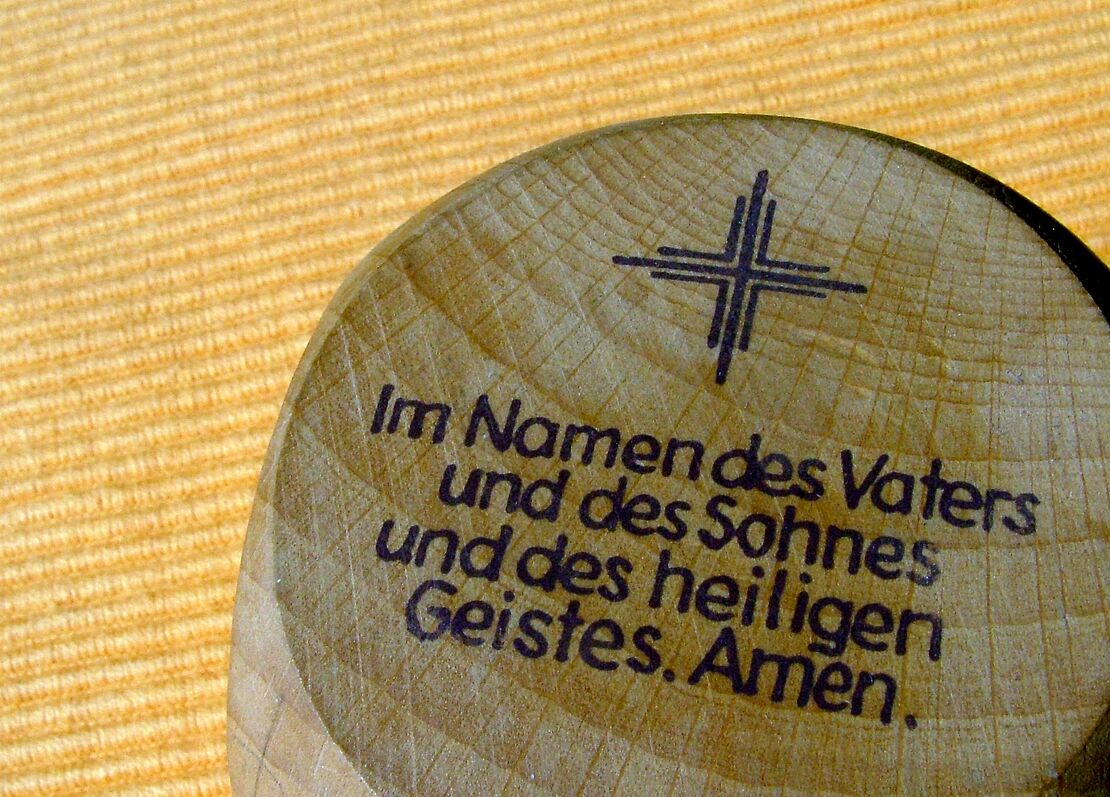 Das Vater Unser eingraviert in einen Holzwürfel.