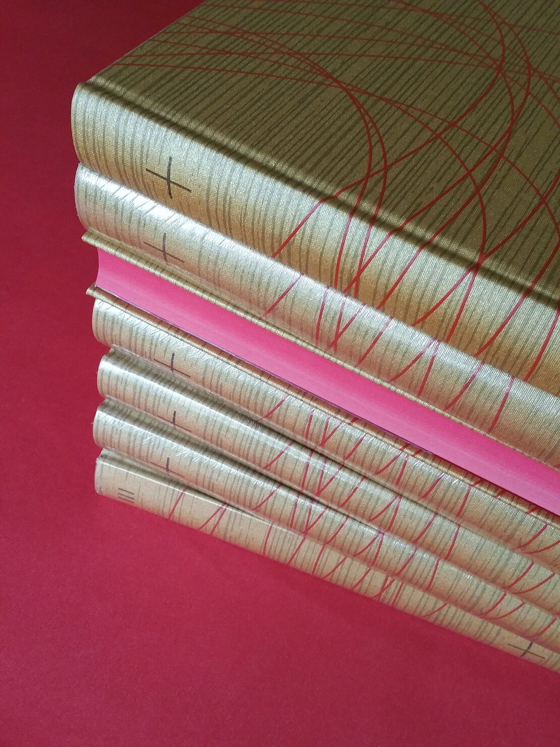 Sieben gestapelte Bücher mit der heiligen Schrift Jesu Christi mit goldenem Einband.
