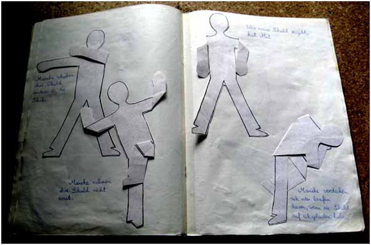 Vier Menschen aus Papier ausgeschnitten und in ein Heft geklebt.