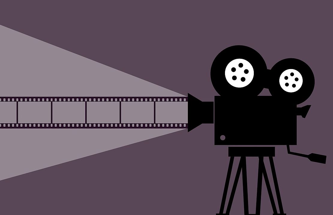 Eine Filmkamera in schwarz vor violettem Hintergrund.